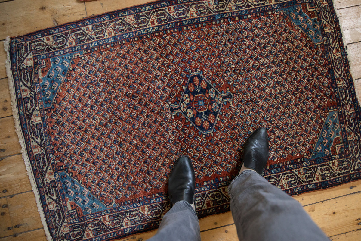 Vintage Tajabad rug corner: sapphire blue spandrel, madder root red boteh field, floral border.