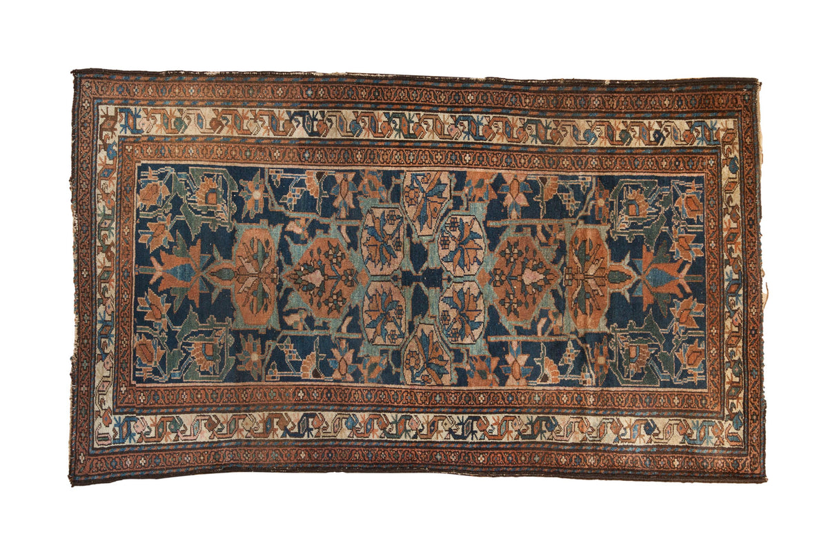 Vintage Persian Mehraban rug, navy field, floral medallions, copper rust, and ivory borders.