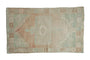 Distressed Oushak rug featuring a rectangular medallion, pale green and beige abrashed field, 3'2" x 5'4".