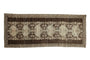 Distressed Anatolian runner rug with charcoal abrashed ground, ivory gul medallions, and vine patterns.