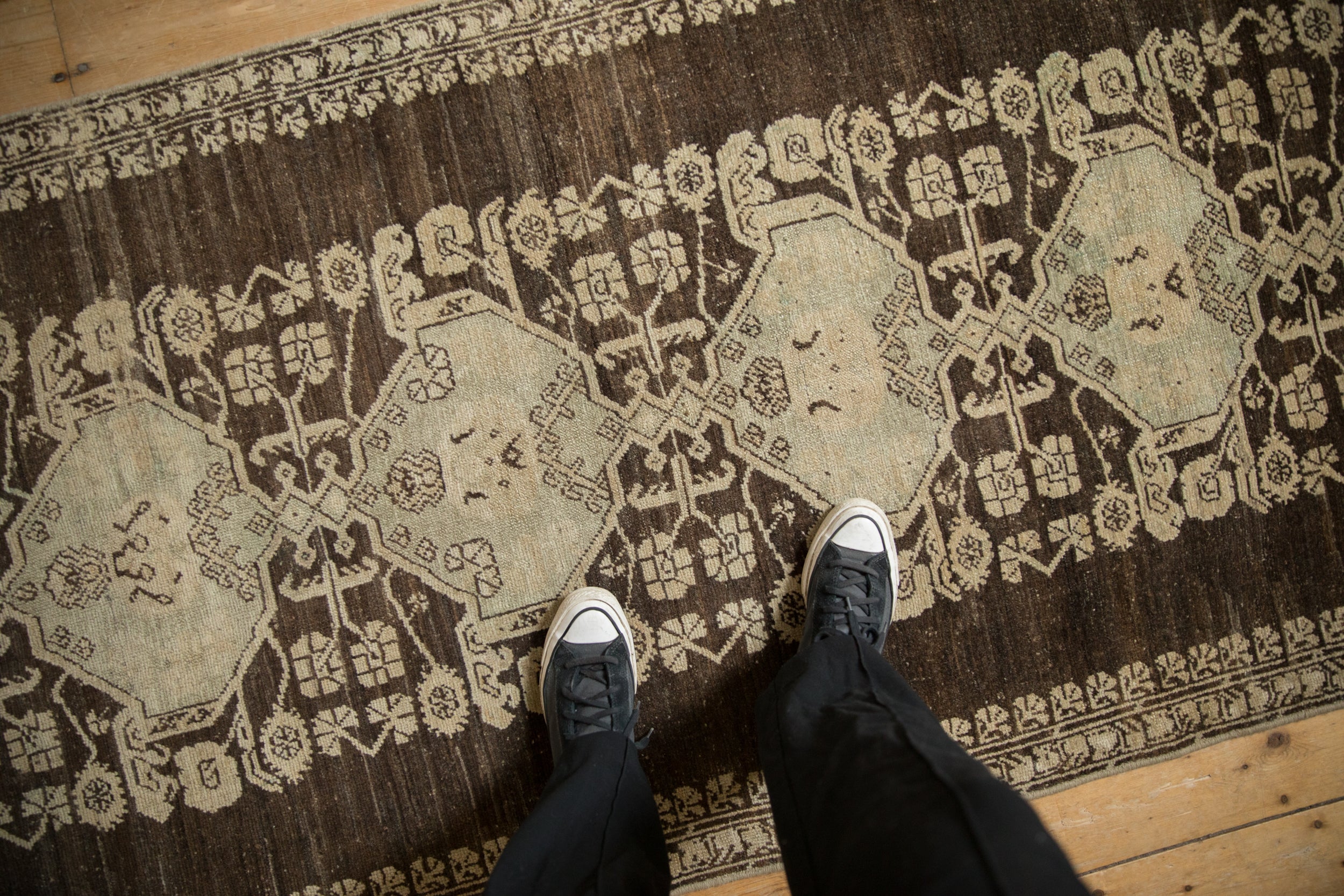 Vintage distressed Anatolian runner section, light gul medallions on abrashed charcoal ground.
