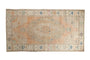 Hand knotted vintage distressed Oushak runner, faded peach medallion, beige field, blue motifs.