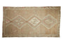 Distressed Kars carpet with central geometric medallions and abrashed field in beige, ivory, pale blush.