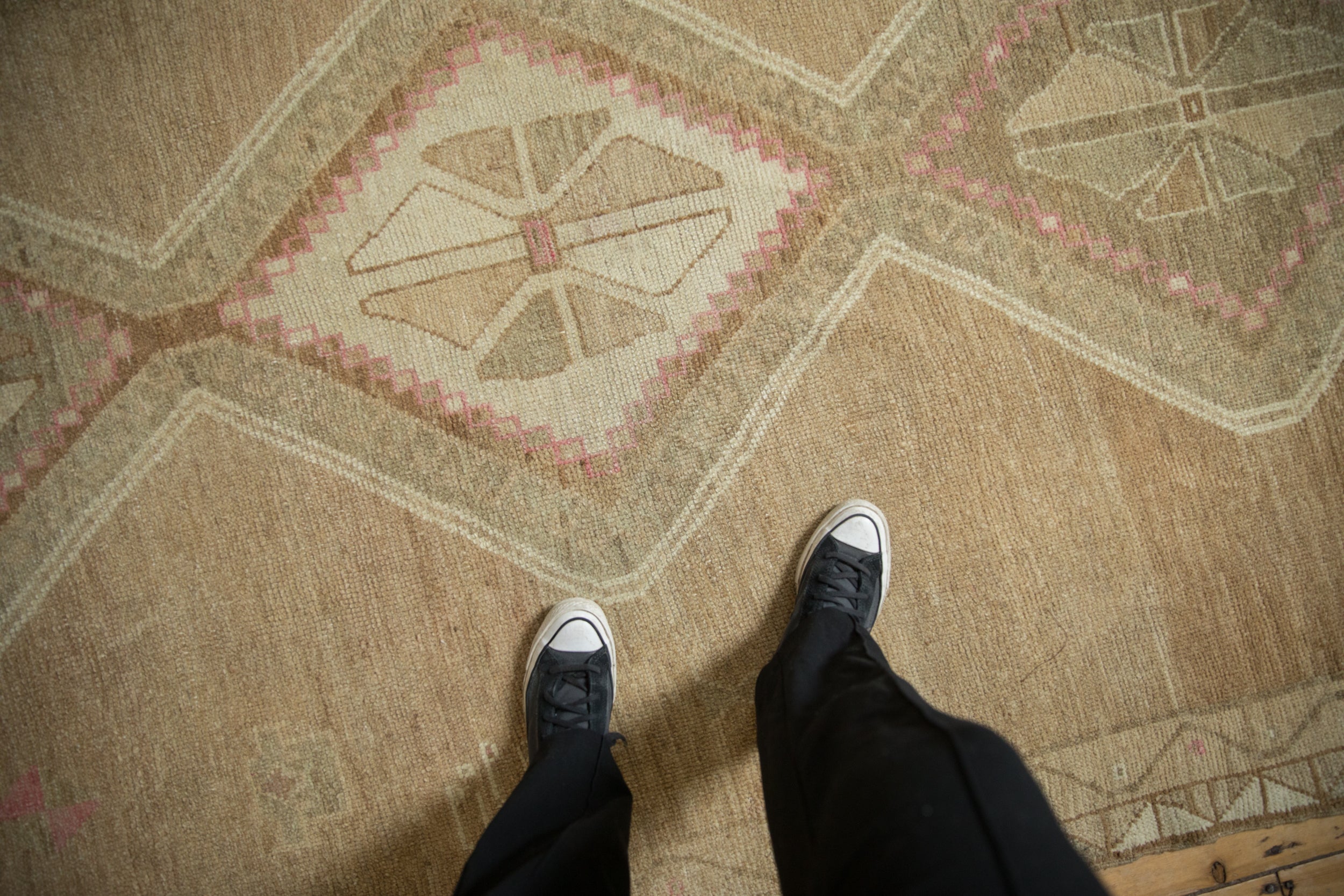 Hand knotted distressed Kars carpet's worn texture with geometric pale blush details.