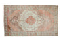 Faded peach and cream vintage distressed Oushak carpet with geometric medallion and borders, 5'6" x 9'9".