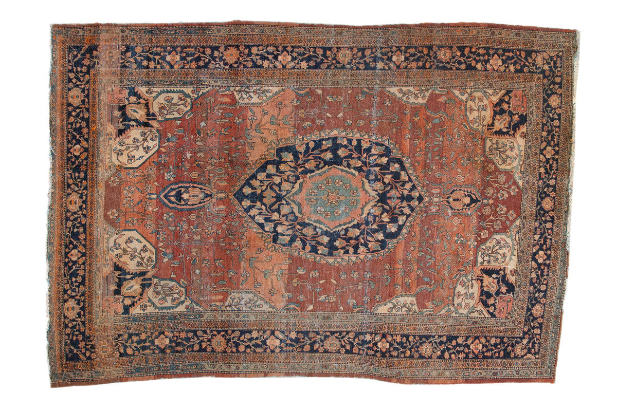 Antique Farahan Sarouk hand knotted carpet with ornate navy medallion, abrashed copper field, floral arabesque.