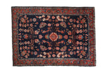 Antique Mohajeran Sarouk rug, navy field with delicate floral vines, central roundel, raspberry border.