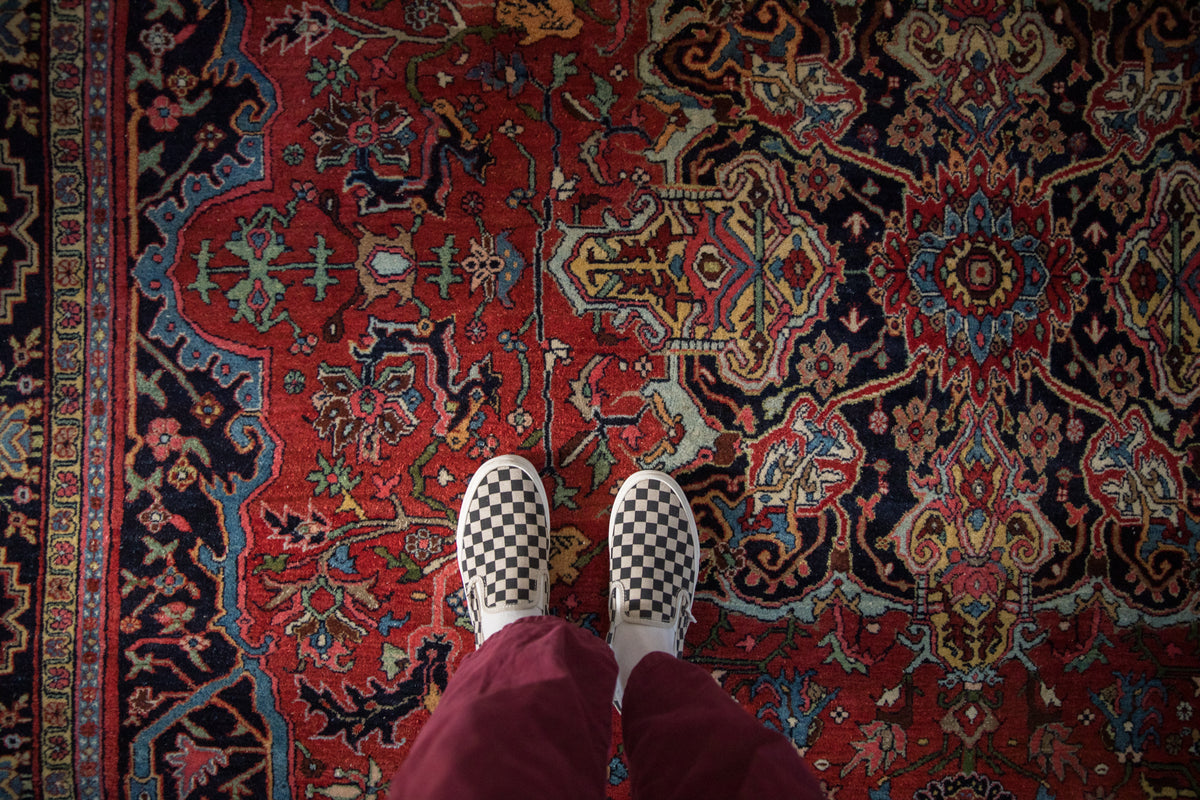 Vintage Bijar carpet with ruby red field, dense floral-geometric motifs, and sapphire blue accents.