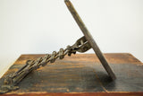 Side view of the antique accordion shaving mirror's extended mechanism with darkened patina.