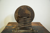 Back of antique accordion shaving mirror showcasing its darkened metal patina and extended mechanism.