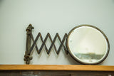 Antique beveled glass accordion shaving mirror with fleur de lis hardware and darkened patina.