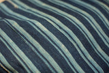 Vintage indigo throw detail with hand-woven blue stripes and textured finish.