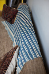 Textured indigo blue and white stripes of the vintage handwoven throw and raw edge.