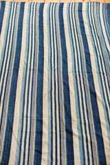 Variegated indigo blue and natural cream striped pattern on a hand-woven collectible textile.