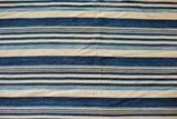 Close-up of hand woven vintage African indigo cotton textile, varied blue stripes.
