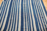 Close-up of vintage hand-woven indigo and natural white striped cotton textile.
