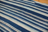 Collectible hand woven indigo cotton textile with varied blue and cream striped pattern.