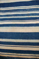 Vintage hand woven indigo textile featuring striped pattern and varied texture.