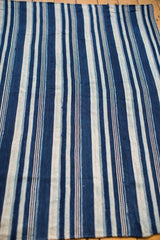 Vintage hand-woven indigo blue and white striped cotton throw with subtle variations.