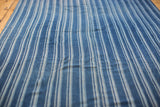 Vintage hand woven indigo textile with varied blue stripes and visible vertical seam.