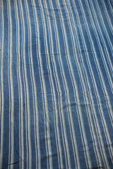 Angled view of hand-woven vintage African indigo blue striped cotton.
