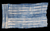 Vintage African indigo textile with hand-dyed blue stripes and patterned vertical border.