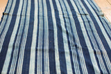 Hand-woven vintage African indigo textile, varying blue shades, supple cotton texture.