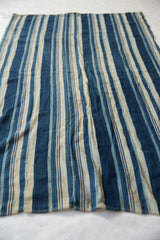 Collectible hand-woven vintage African indigo textile with striped blue and cream.