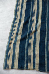 Vintage African indigo textile, displaying blue and natural hand-woven striped pattern and texture.