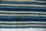 Handwoven vintage African indigo textile featuring varied blue and cream stripes.