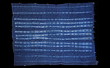 Deep blue hand-woven African indigo cotton with intricate resist-dyed dot pattern.