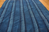 Hand-woven indigo blue striped throw, showcasing varying shades and natural texture.