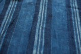 Variations in hand-dyed indigo blue stripes on a vintage textile.