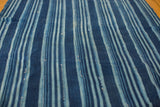 Close-up of indigo blue striped textile, showing varied blue tones and handwoven texture.