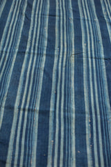 Vintage African indigo textile with handwoven texture and varied blue striped pattern.