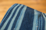 Vintage indigo striped textile with hand-woven texture and unique blue dye variations.