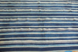 Hand-woven vintage African indigo textile featuring varied blue and cream stripes.