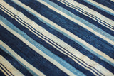 Handwoven vintage indigo textile texture with varied blue and natural cream stripes.