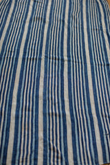 Detail of hand-woven indigo blue and natural white striped textile texture.