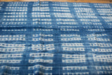 Close-up of vintage African indigo textile, hand-woven blue cotton with resist-dyed white patterns.