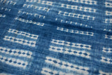 Handwoven vintage African indigo textile featuring intricate blue and white geometric patterns.