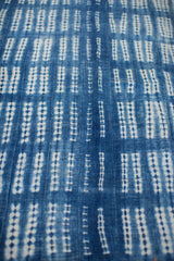 Close-up of hand-woven vintage indigo textile with white resist-dyed dots.