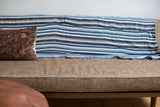 Vintage Indigo Stripe Throw with blue and light beige handwoven stripes draped on a sofa.