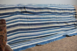 Hand woven texture and varying blue stripe design of the vintage indigo throw.