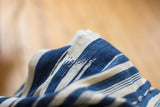 Hand-woven vintage indigo and cream striped textile with subtle stitched repairs.