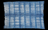 Textured hand-woven indigo textile showing white resist-dye patterns and vintage character.
