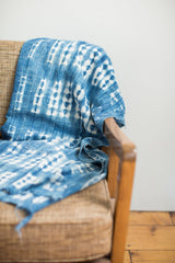 Draped vintage African indigo textile showcasing its hand-dyed patterns and texture.