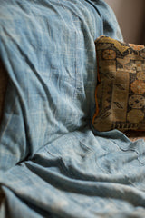Hand-woven indigo blue cotton throw with soft drape and visible stitching.