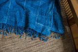 Frayed indigo fringe and subtle white batik pattern on a folded vintage textile.