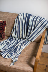 Hand-woven indigo blue and off-white striped textile draped fluidly.